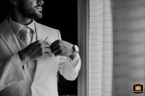 Black and white close-up of the groom adjusting his pocket in Gordes.